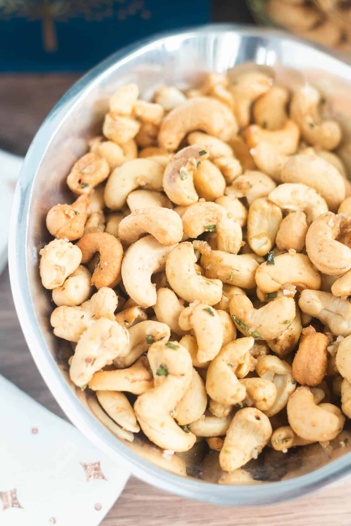 Roasted rosemary cashews in a silver bowl. 
