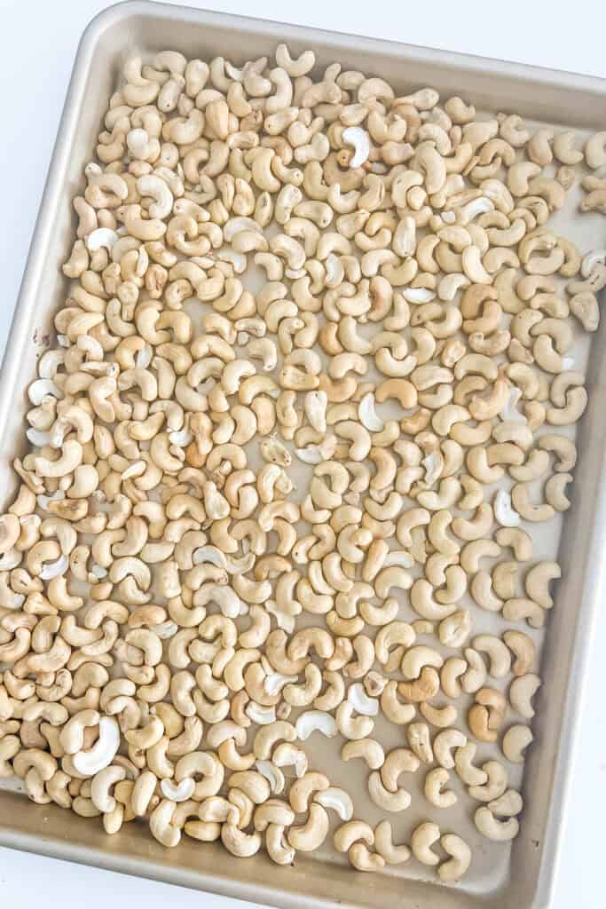 Cashews spread on a baking sheet.