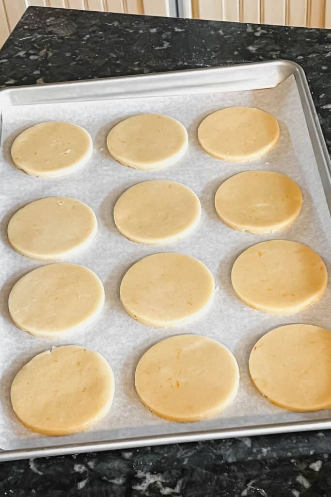 Round unbaked sugar cookies on a tray. 