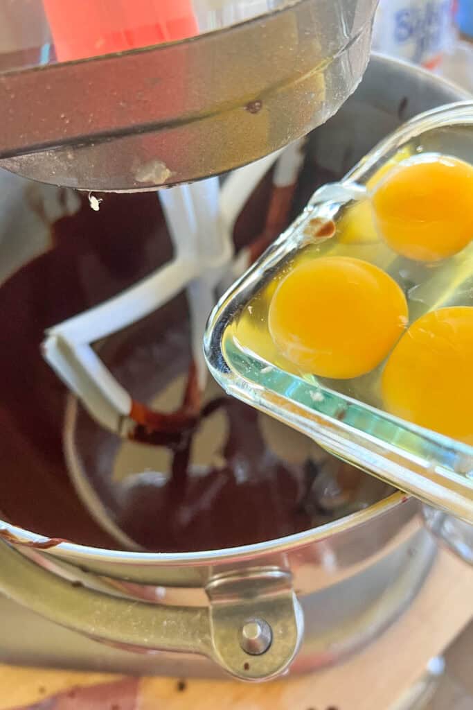 Adding eggs to the bowl.