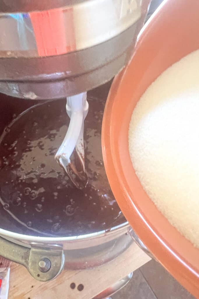 Adding sugar to the batter.