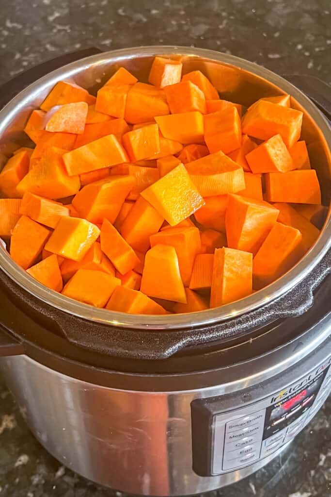 Sweet potatoes, butternut squash and broth added to instant pot. 