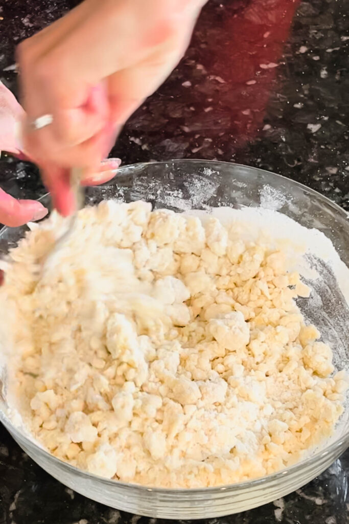 Mixing pie crust dough until crumbly. 