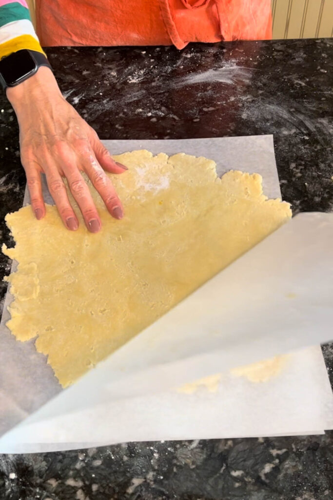Roll out pie crust dough between two pieces of parchement paper. 