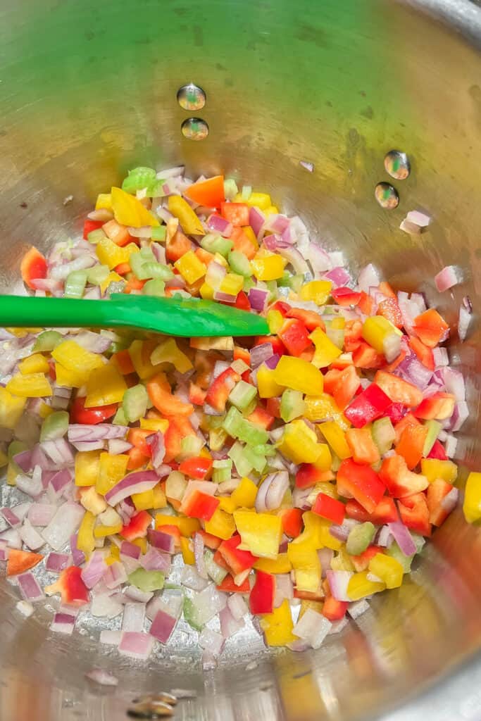 Adding celery and peppers to red onions. 