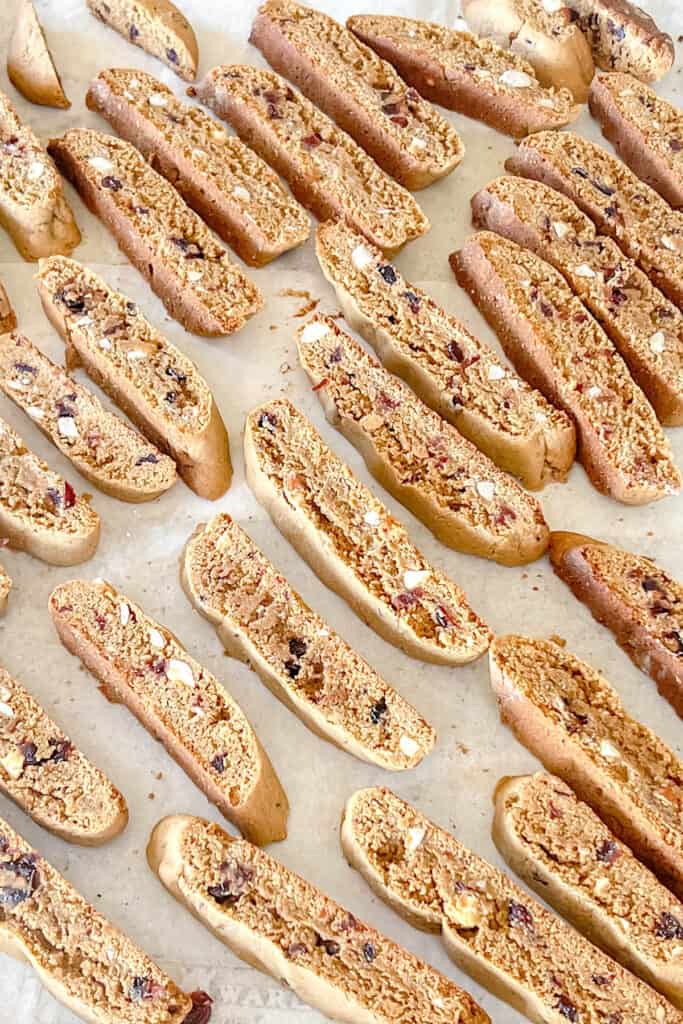 Slices of baked biscotti on a baking sheet. 