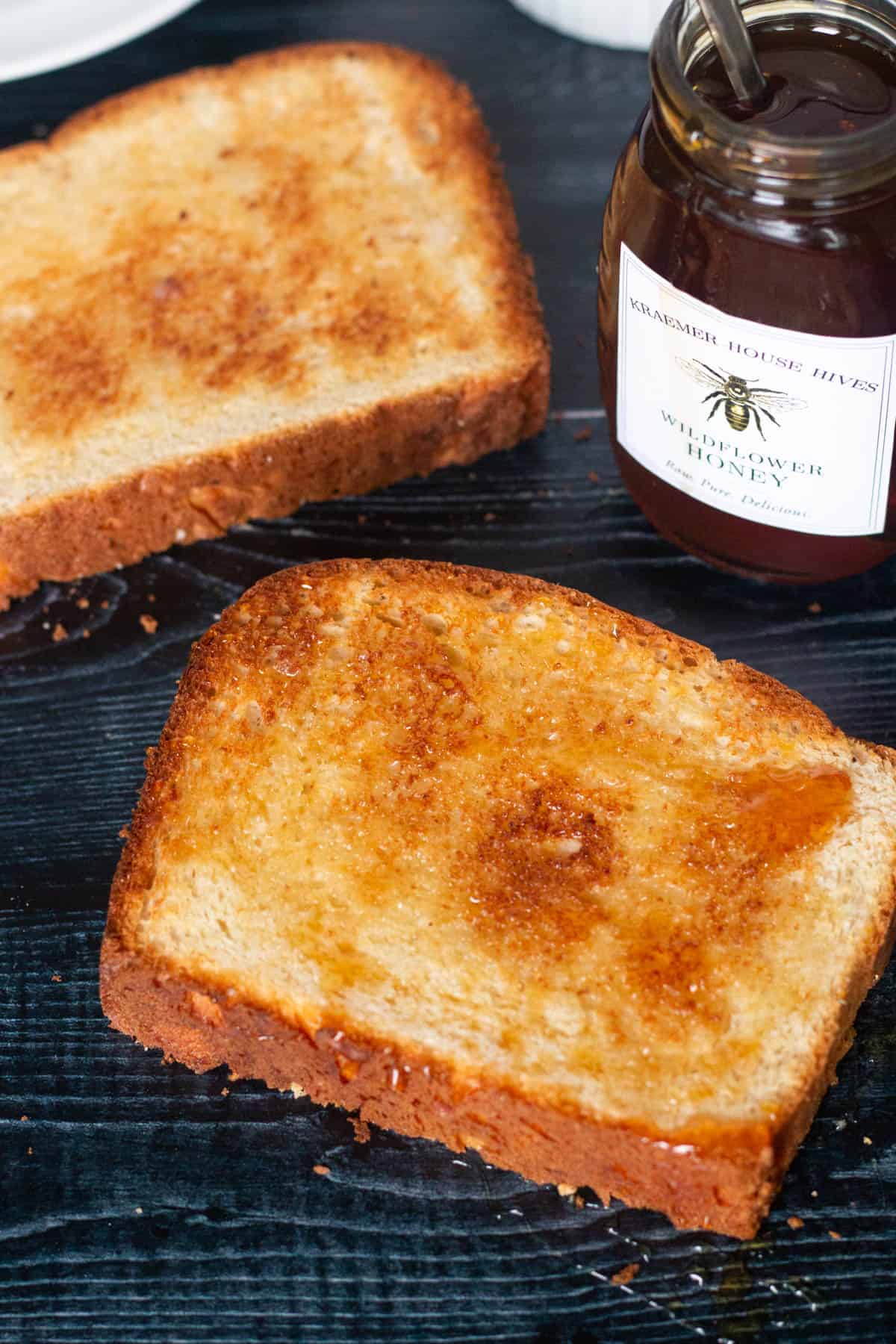 Two slices of toasted potato bread with a honey drizzle. 