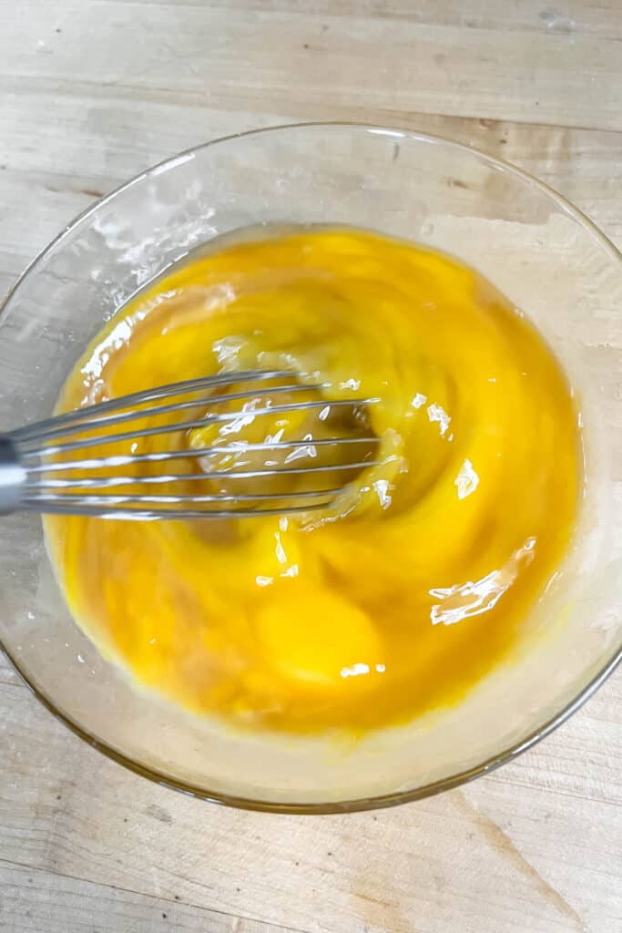 Whisking eggs, vanilla and brandy in a small bowl. 