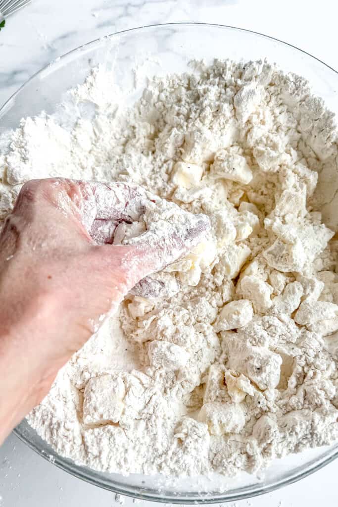 Mixing in cubed butter by hand. 