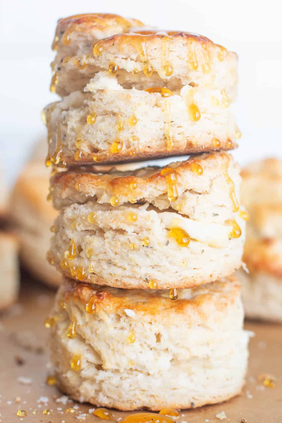 Stack of three homemade buttermilk biscuits with honey. 