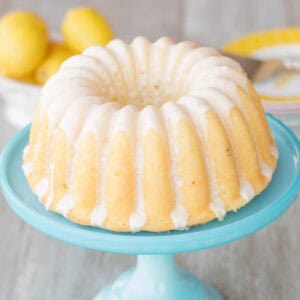 Whole glazed lemon bundt cake on a cake stand.