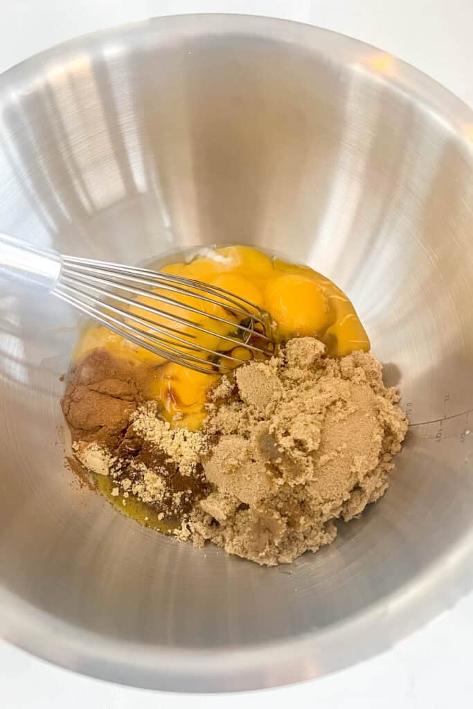 Eggs, brown sugar, spices and molasses in a mixing bowl.