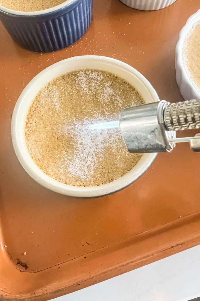 Torching the sugar on the gingerbread creme brulee with a kitchen torch. 