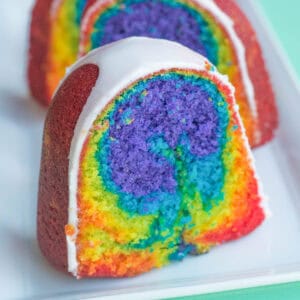 Slice of rainbow cake with lemon glaze.