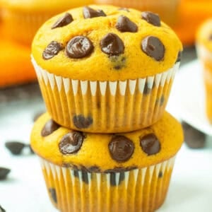 Two stacked pumpkin chocolate chip muffins.