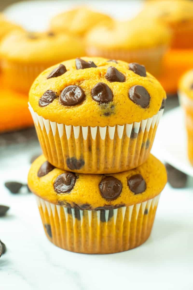 Two stacked pumpkin chocolate chip muffins.